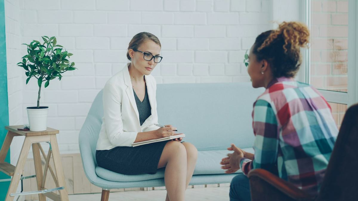 A therapist listening to a client in a bright session room